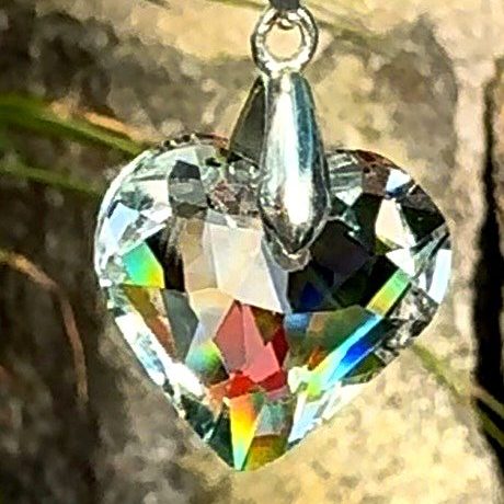 Heart-shaped crystal pendant reflecting rainbow light