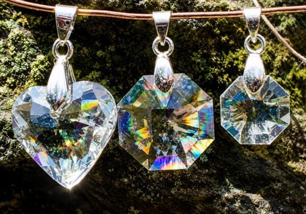 Three sparkling crystal pendants reflecting rainbow light